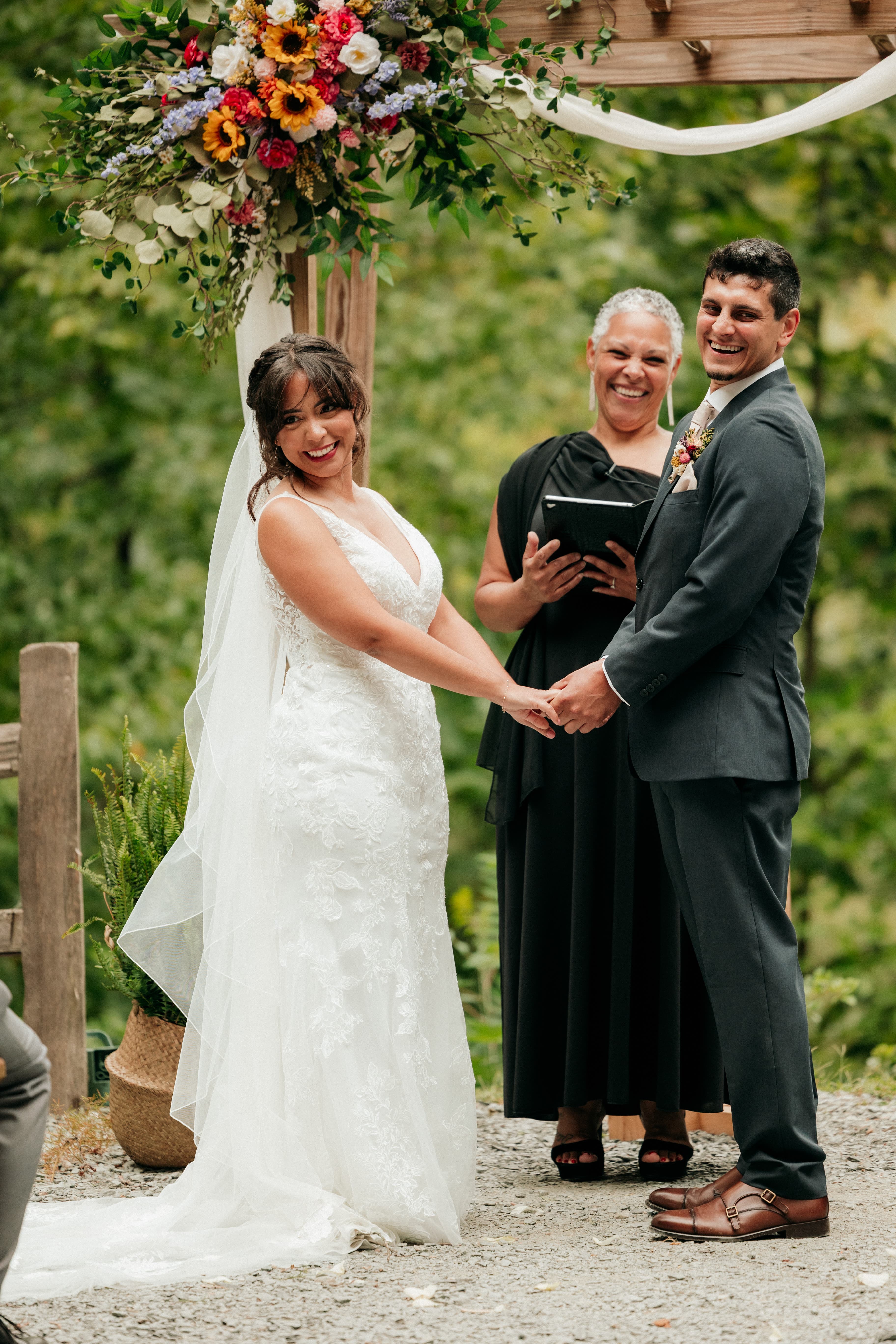 Professional wedding officiant warmly leading a personalized ceremony while a couple and their guests listen